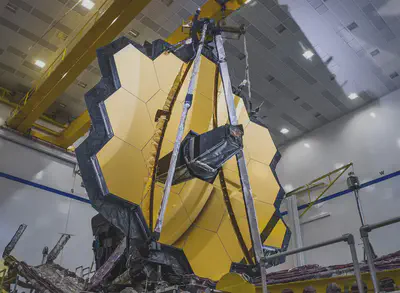 Una foto del Telescopio Espacial James Webb de la NASA/ESA/CSA tras una prueba de despliegue con éxito de su espejo primario en la misma configuración que tendrá cuando esté en el espacio. Fuente: https://www.esa.int/ESA_Multimedia/Images/2020/04/James_Webb_Space_Telescope_s_primary_mirror_unfolded.